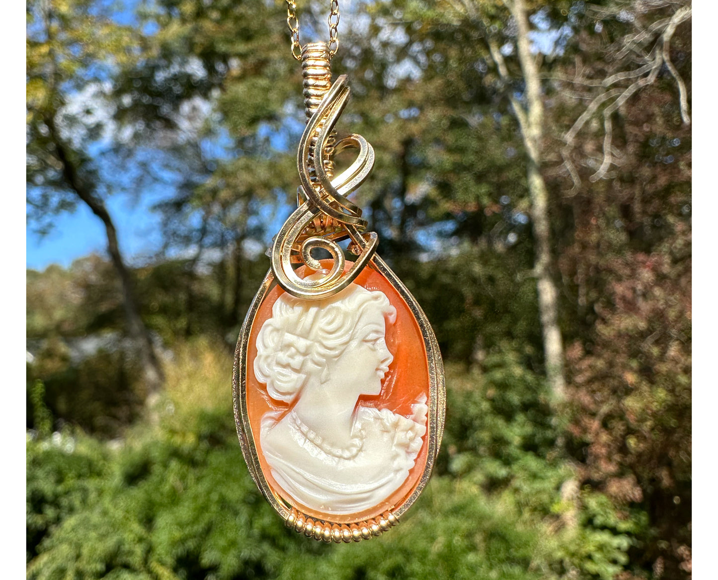 Wire wrapped 14k goldfilled wire pendant of a handcarved shell vintage cameo of a woman with a pearl necklace and flowers